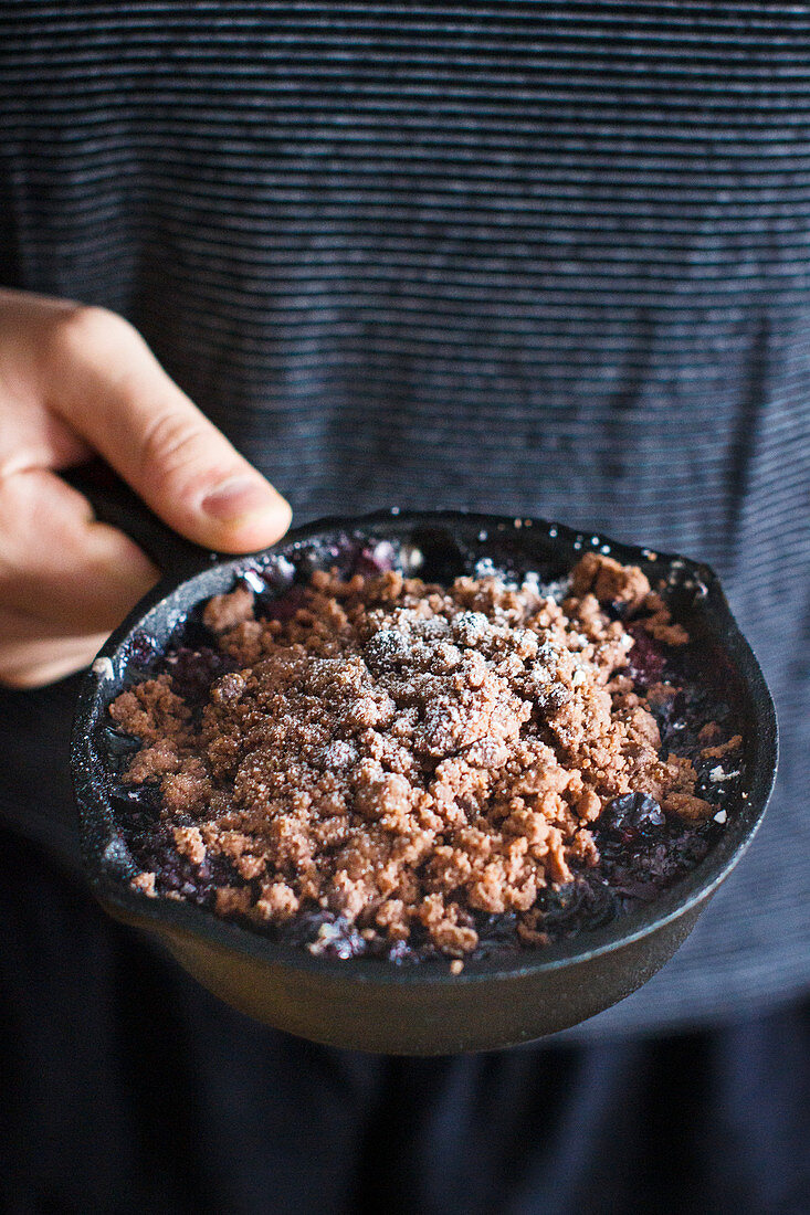 Chocolate crumble with berries in a cast iron pan