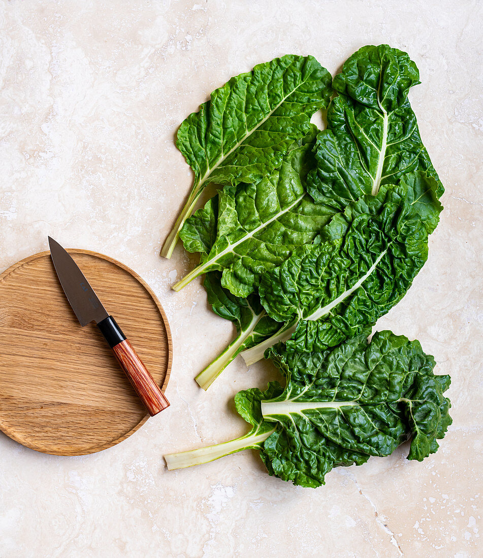 Spinach leaves with wooden board and knife