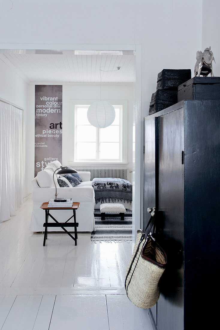 View past black cupboard into black-and-white living room