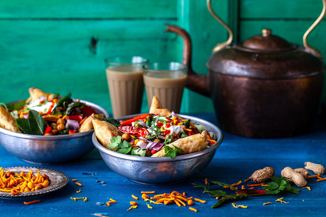 Chaat-Salat (scharfer Kichererbsensalat, Indien) mit Samosas und Erdnüssen