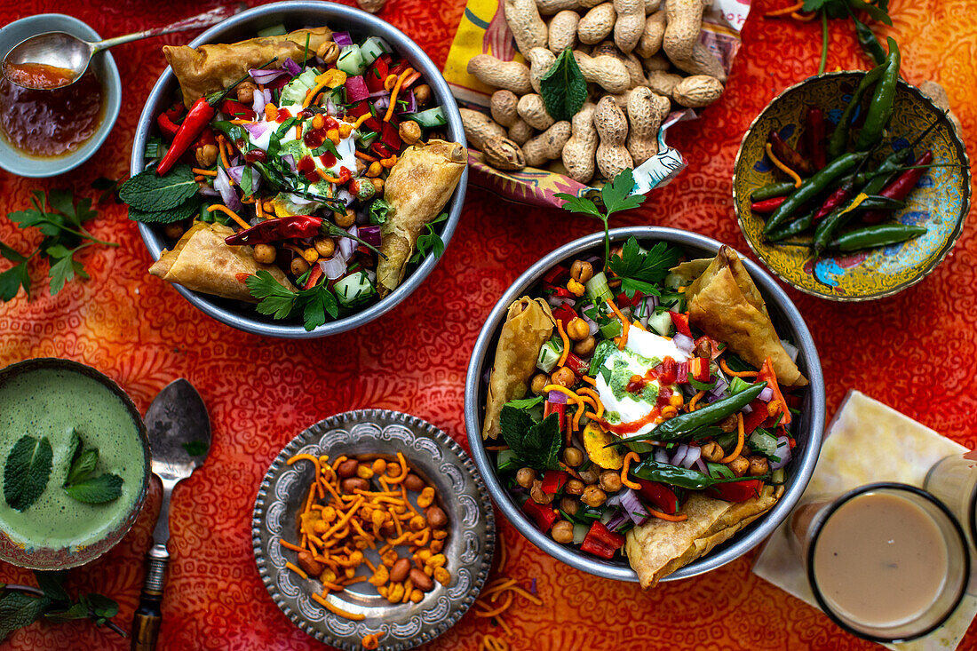 Chaat-Salat (scharfer Kichererbsensalat, Indien) mit Samosas und Erdnüssen