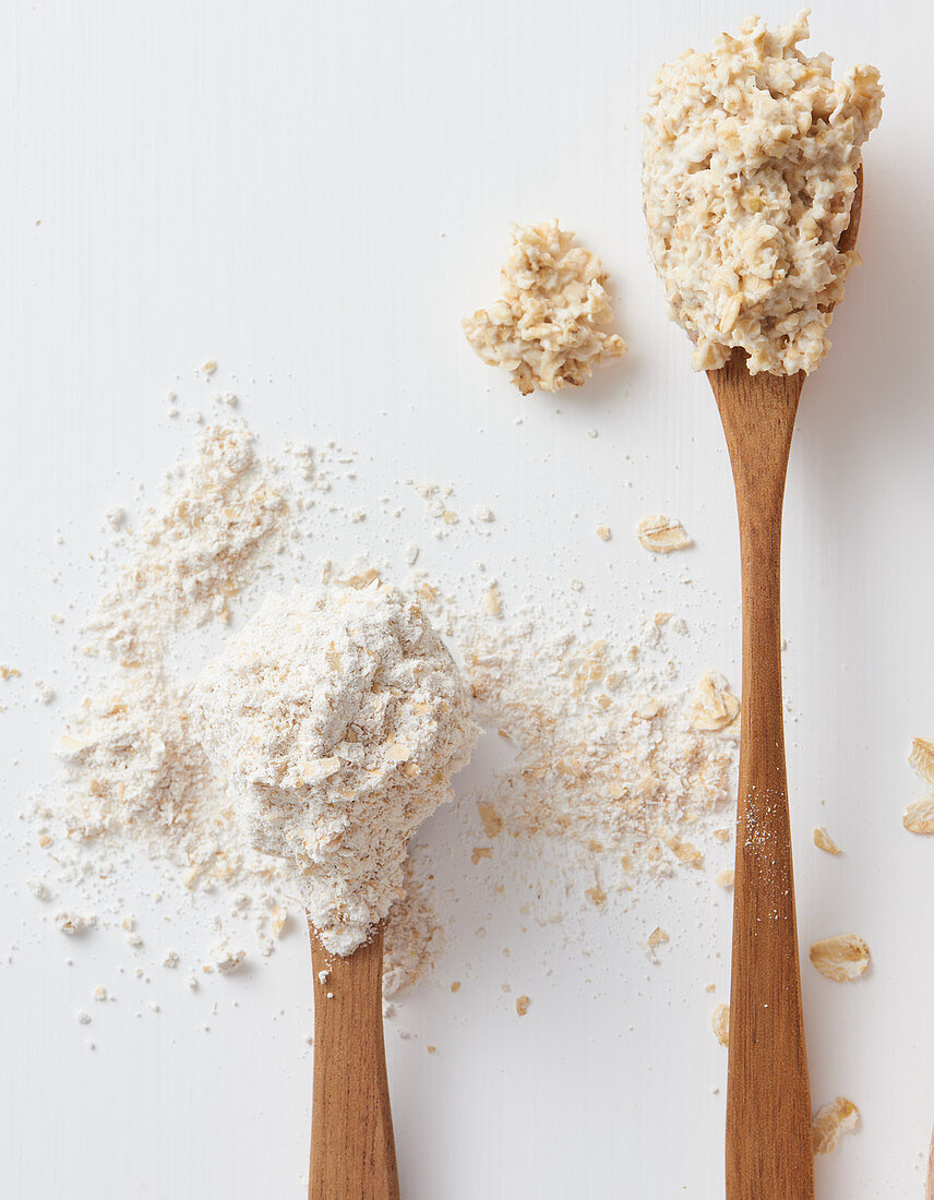 Porridge and oatmeal on wooden spoons