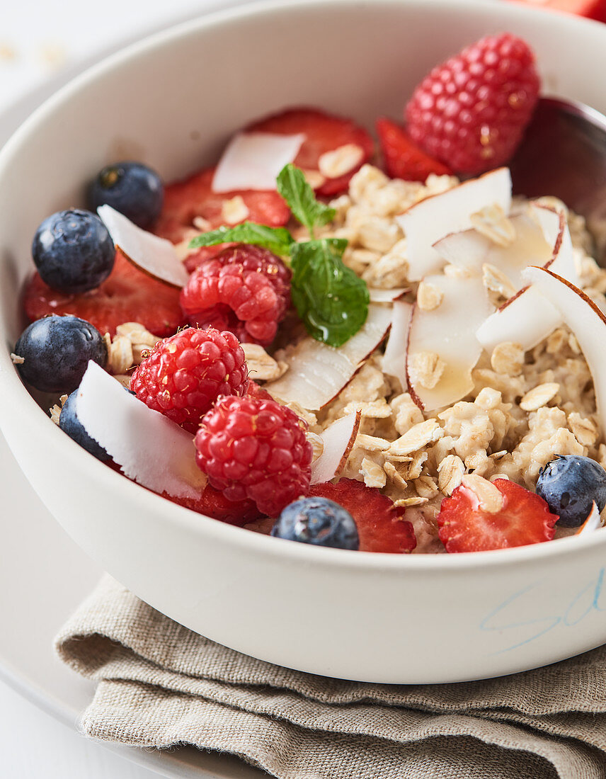 Porridge with fresh berries and coconut flakes