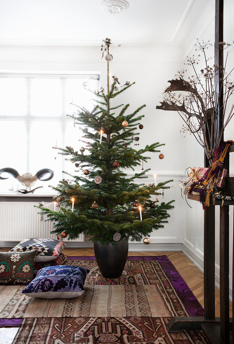 Weihnachtsbaum und Kissen auf Ethno-Teppichen im Lagenlook