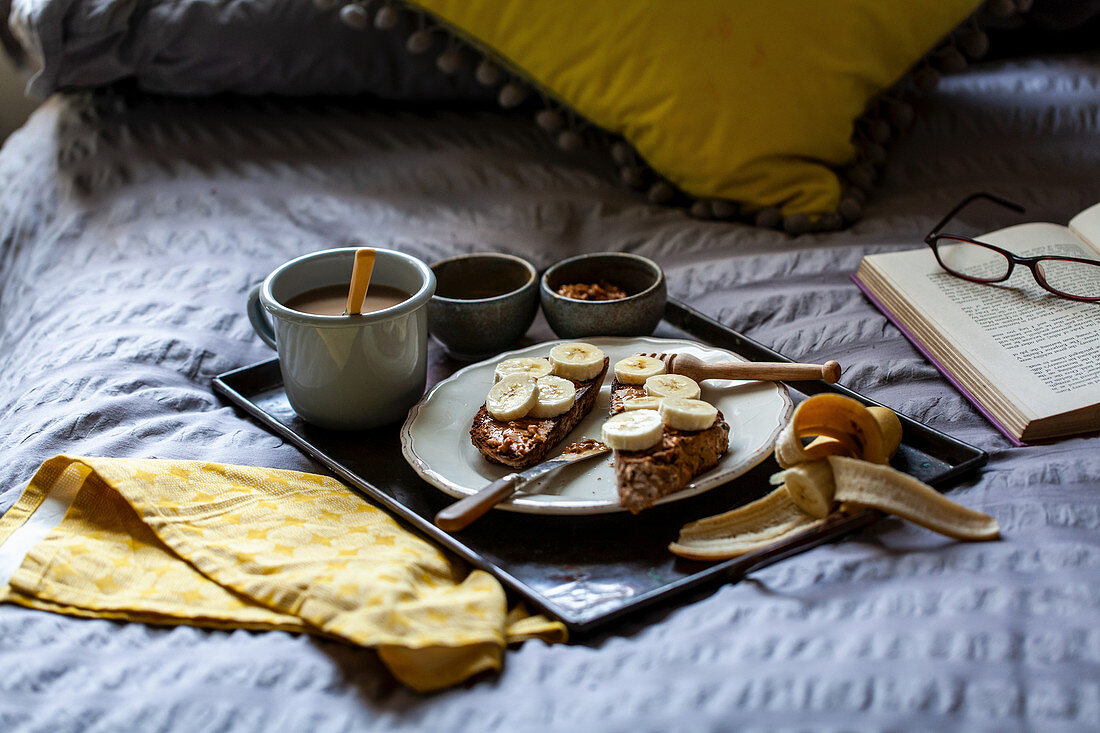 Frühstück im Bett mit Bananenbrot, Erdnussbutter und Tee