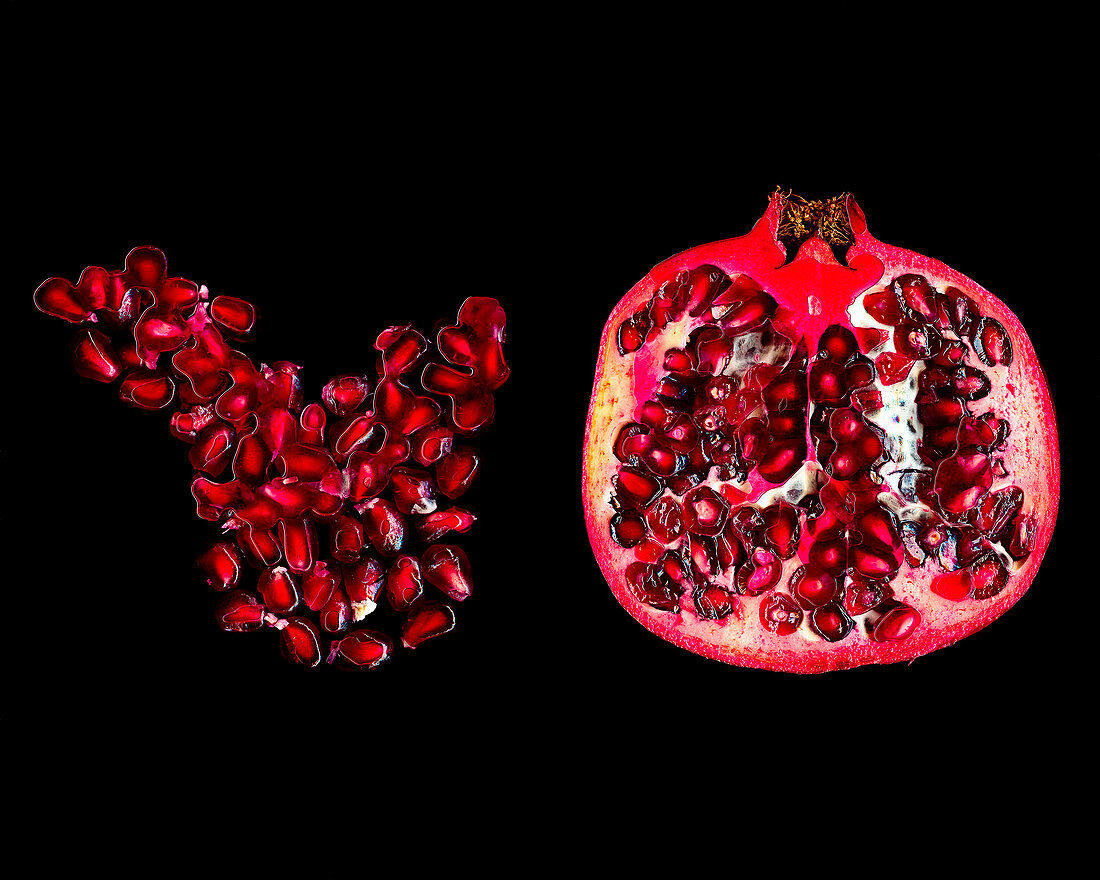 Sliced Pomegranate and Seeds on Black Background