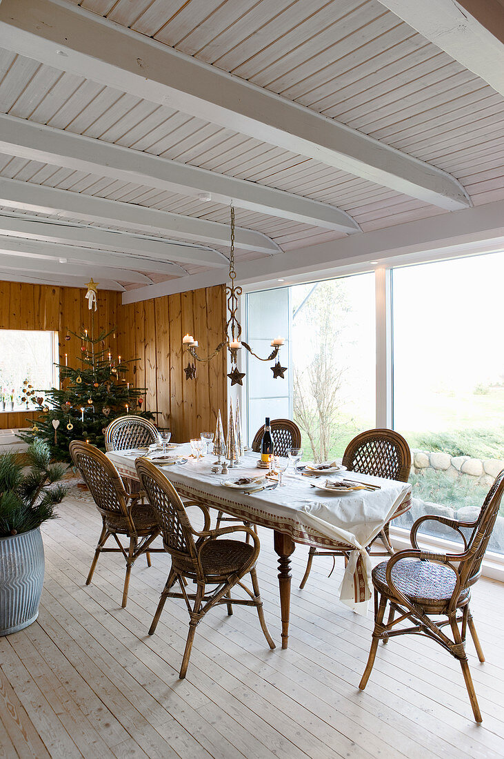 Set dining table and bamboo chairs in festively decorated interior
