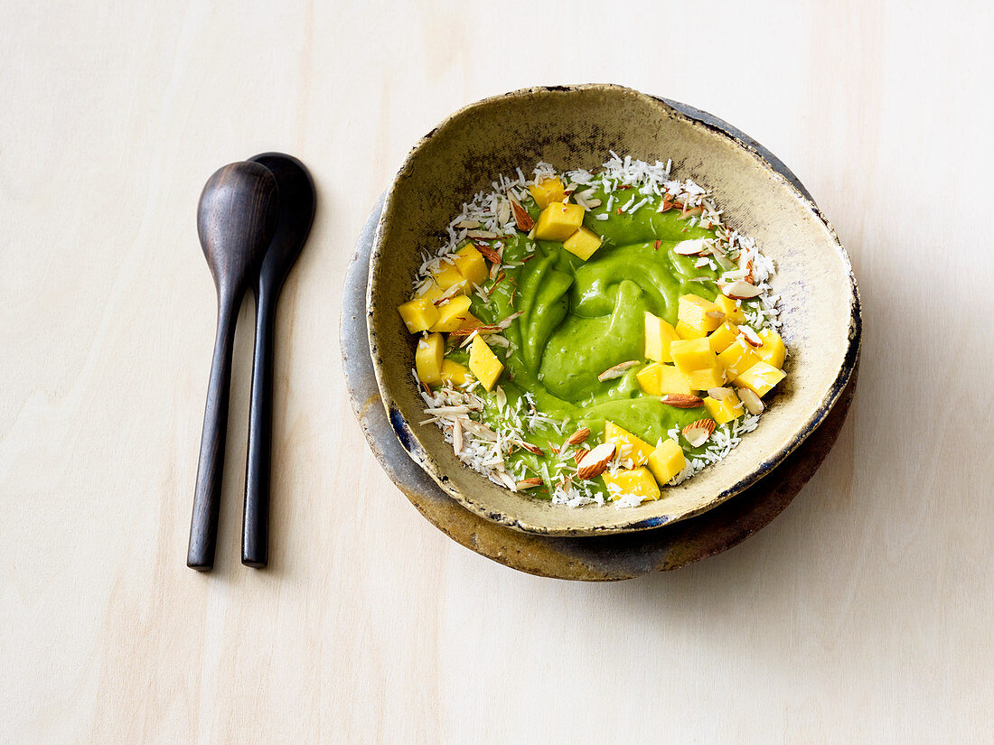 A green smoothie bowl with spinach, avocado, mango and coconut