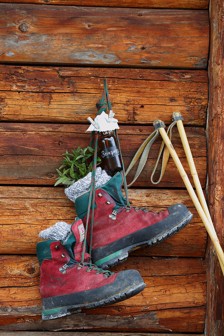 Hiking boots and bottle of leg spray hung on cabin wall