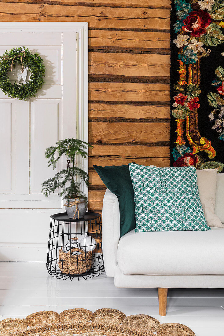 Wandteppich überm Sofa im Wohnzimmer mit Holzwand