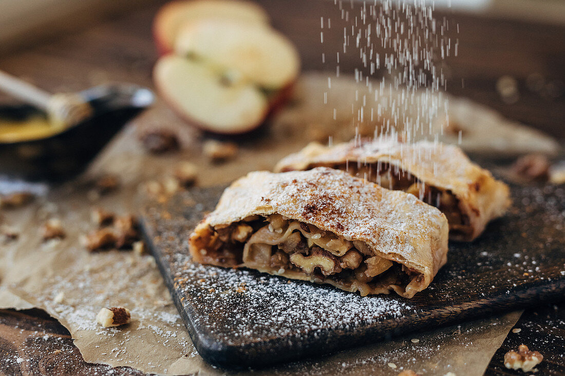 Dusting apple strudel with icing sugar