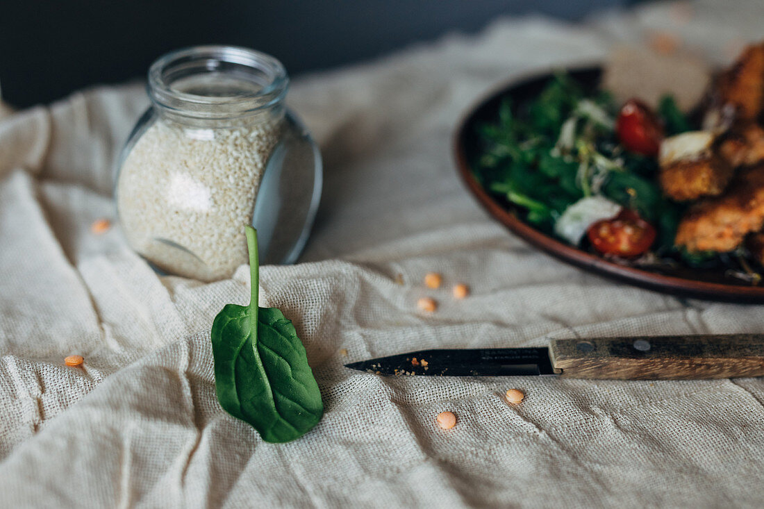 An arrangement of ingredients with salmon burgers with salad in the background