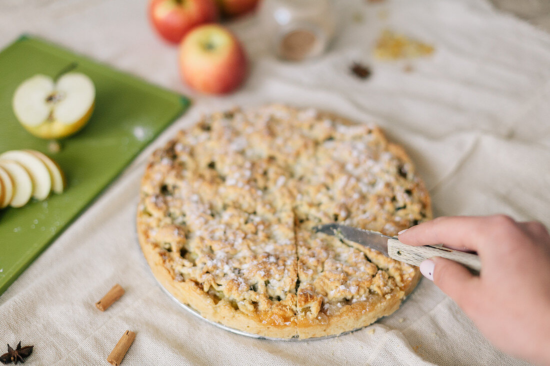 Apple cake with a crumble topping being sliced