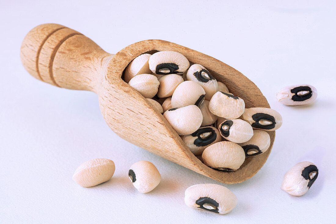 Eye beans in a wooden bailer on a white background