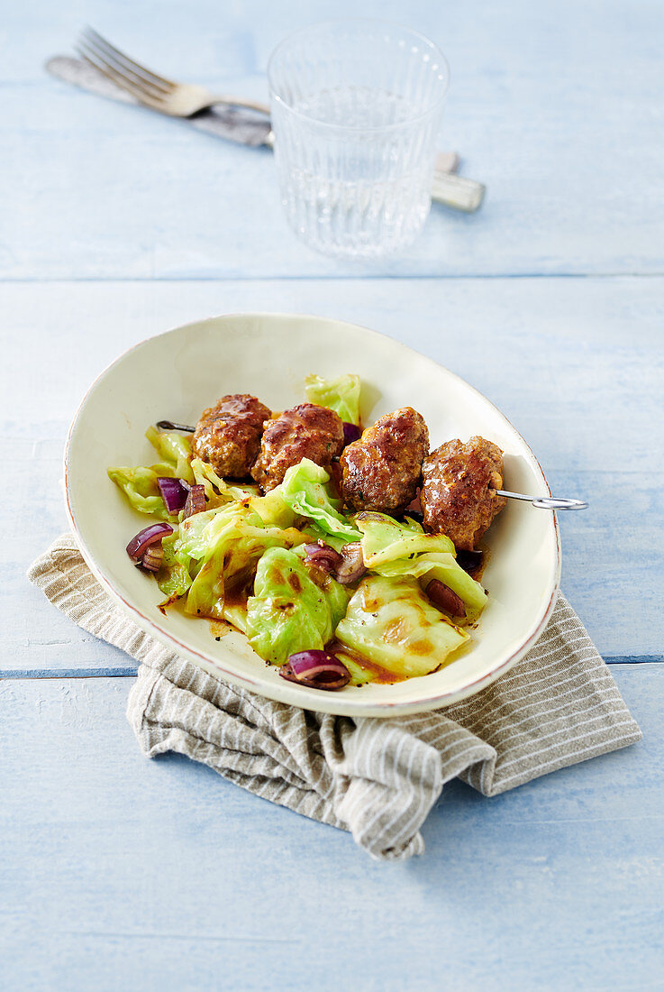 A meatball skewer with pointed cabbage