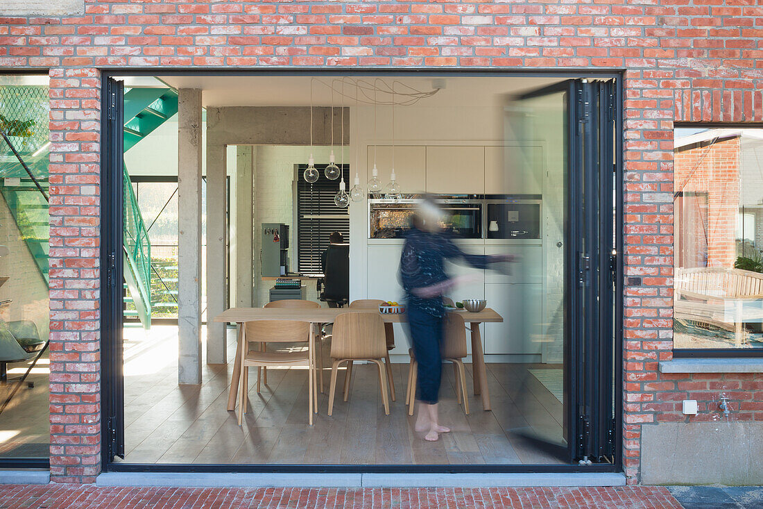 View of modern kitchen with dining table through patio door