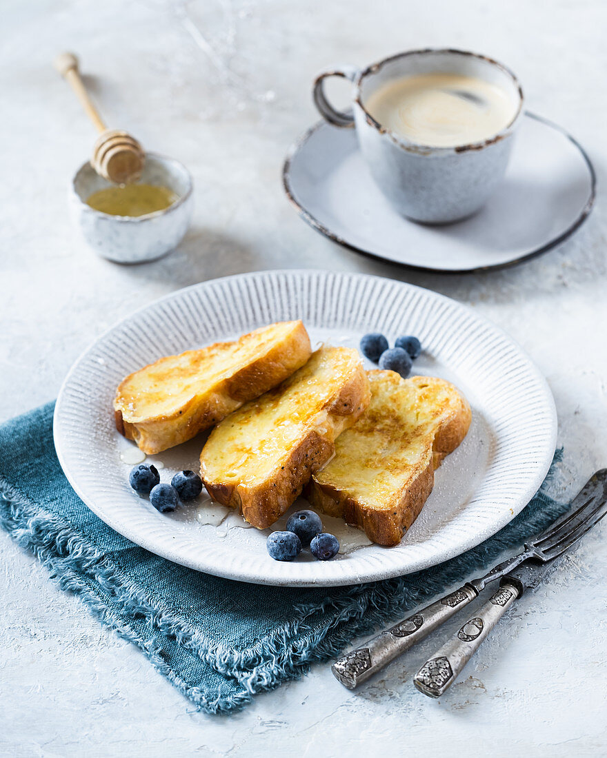 French Toast mit Blaubeeren und Honig, dazu Kaffee