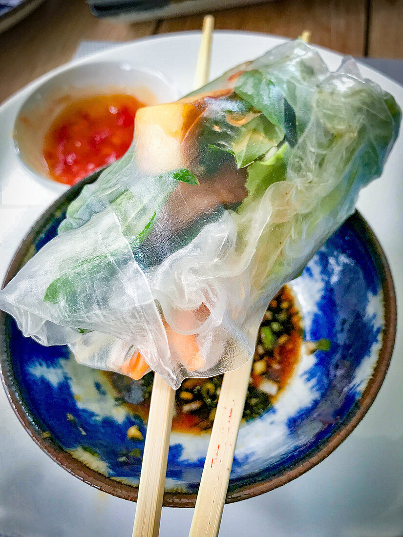 A Vietnamese spring roll on chopsticks
