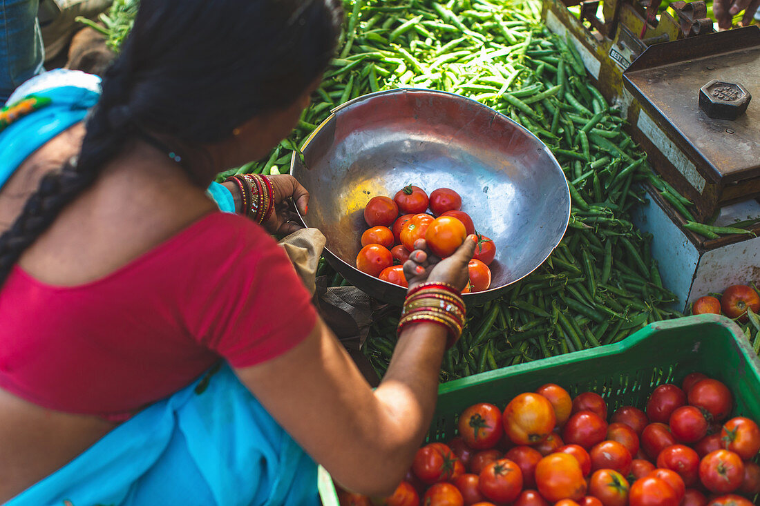 Frau verkauft Gemüse auf einem Markt (Indien)