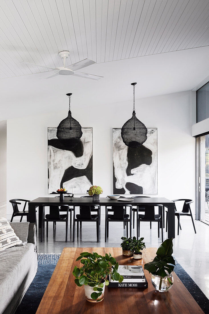 Tisch und Stühle in Schwarz im offenen Wohnraum mit hoher Decke