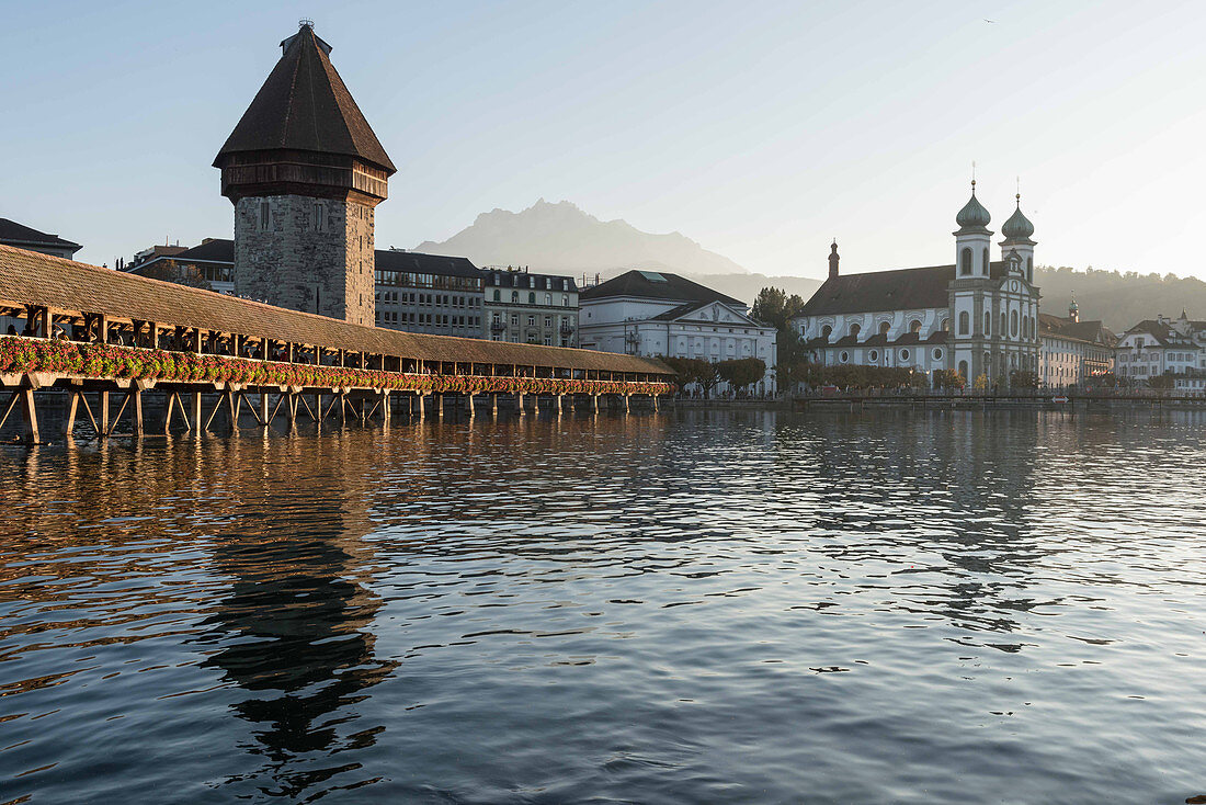 The Kapellbrücke (Chapel Bridge) over the River Reuss with the water tower and the Jesuit Church, Lucerne, Switzerland