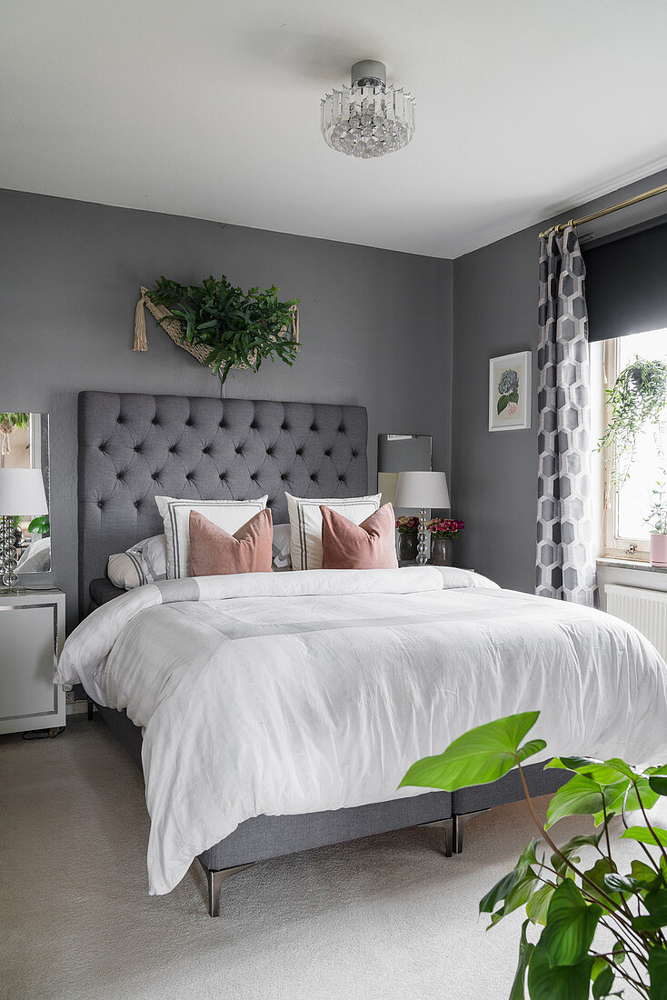Gepolstertes Betthaupt im eleganten Schlafzimmer in Grau und Weiß