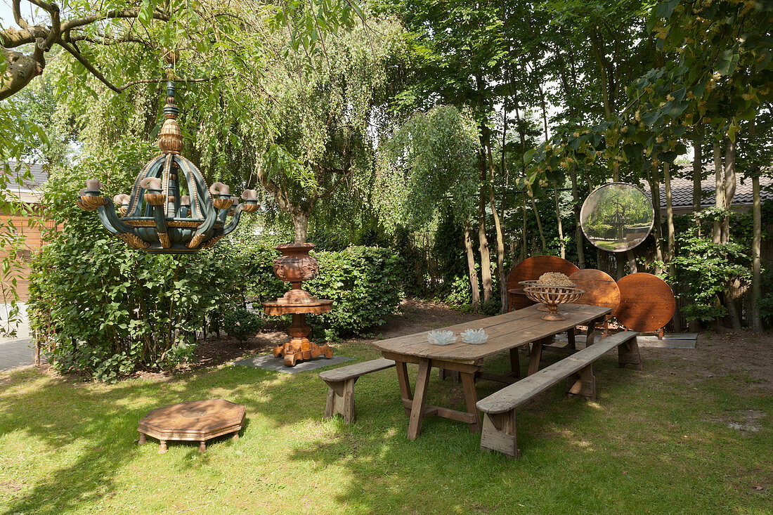 Table, benches and artistic decorations in garden