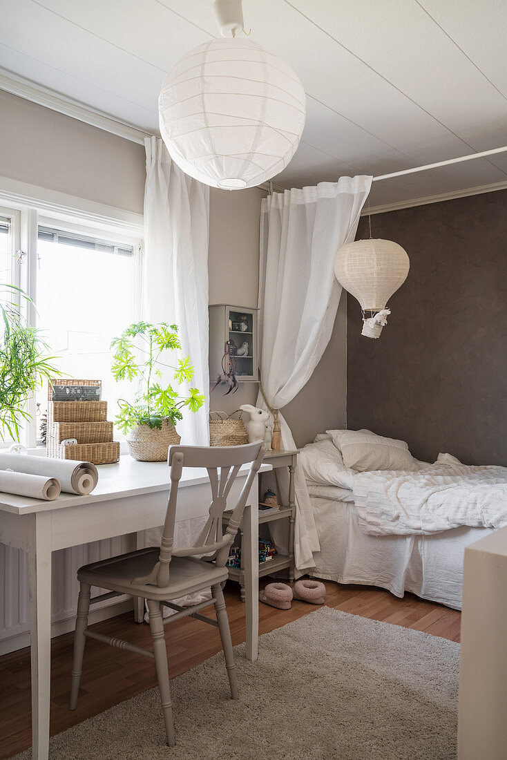 Desk below window in child's bedroom decorated in white and grey