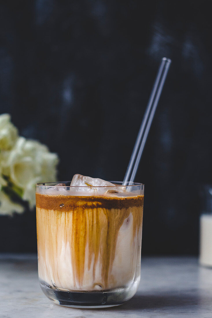 Iced coffee latte in a glass with a straw