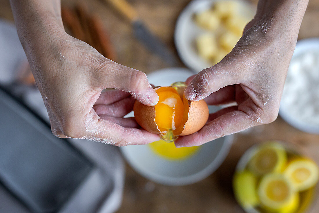 Breaking fresh chicken egg into bowl