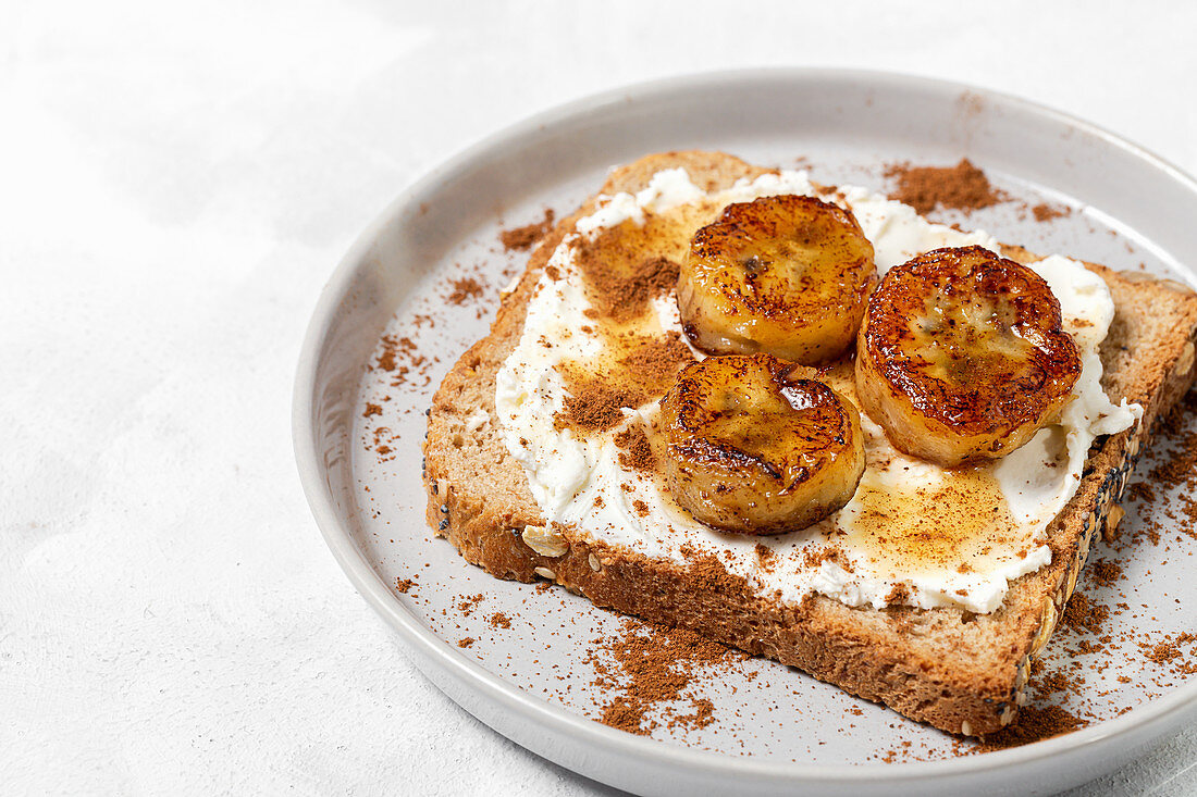 Homemade toasted bread with cream cheese, fried banana, honey and cinnamon