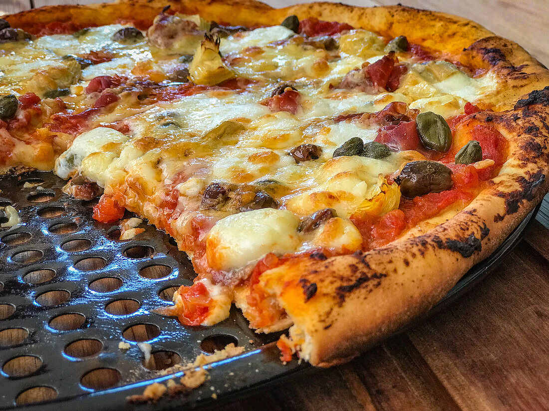 A pizza on a grilling rack