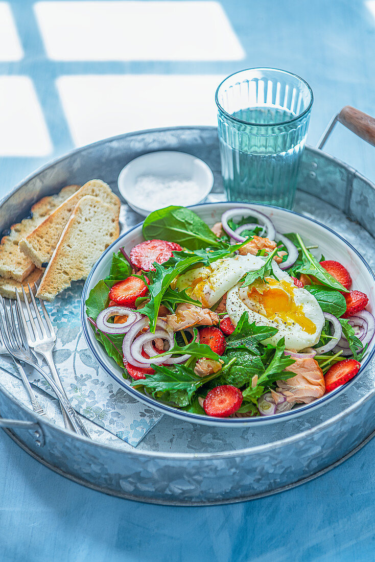 Garden leaves, hot smoked salmon salad with strawberries and poached egg
