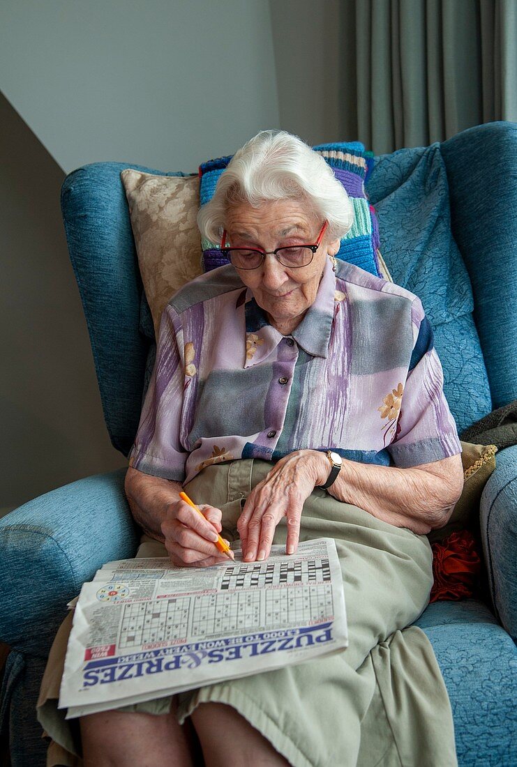 Care home resident doing a crossword puzzle