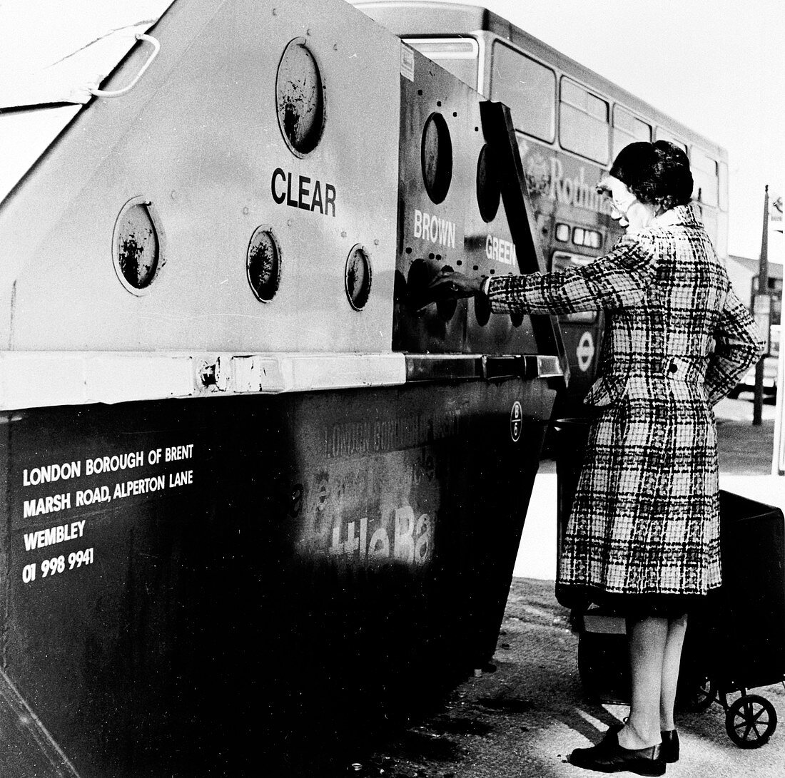 Woman using a bottle bank in Brent, London, c1950s