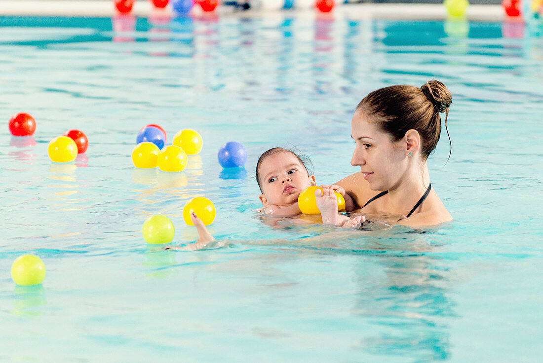 Baby boy with mother in swimming pool