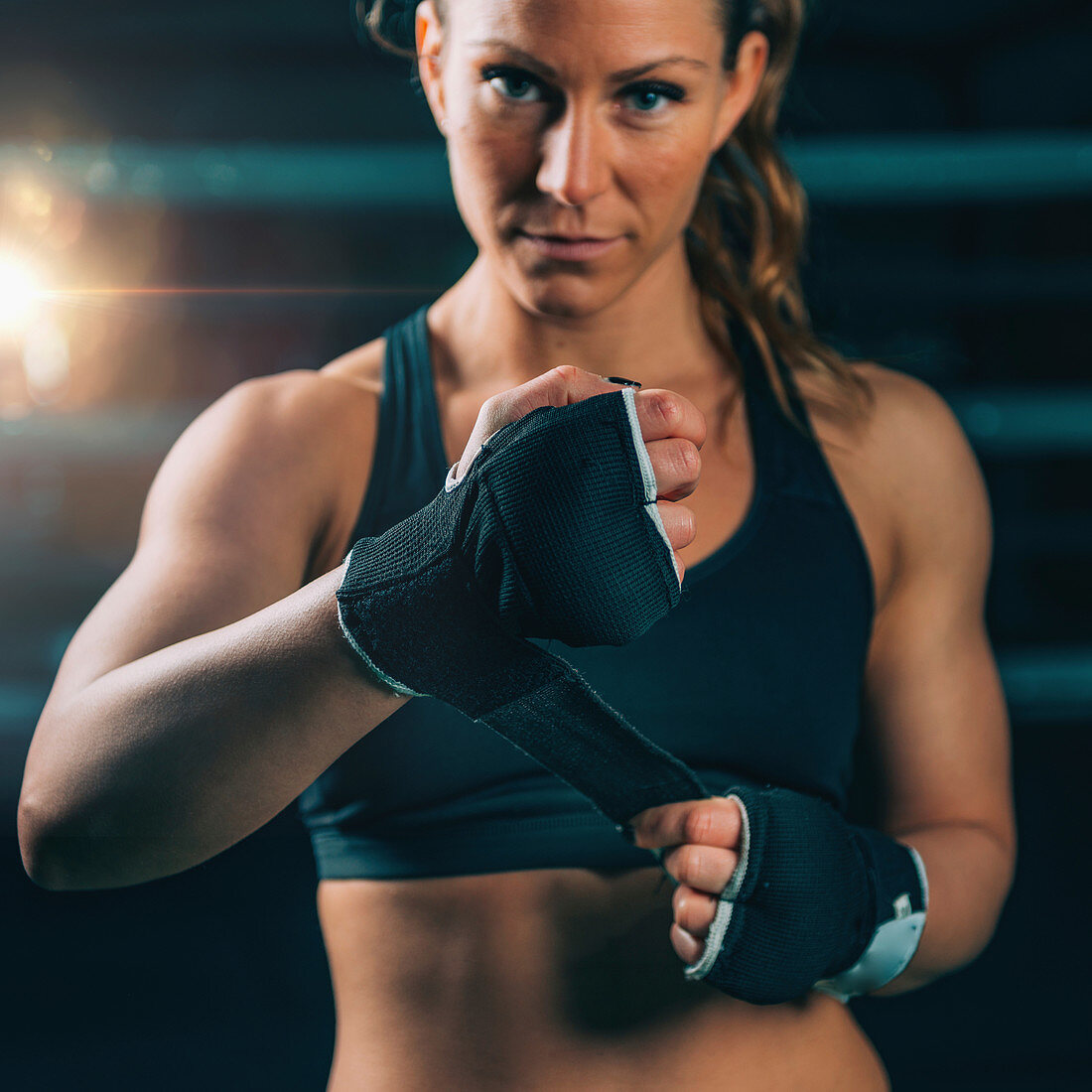 Female boxer wrapping hands