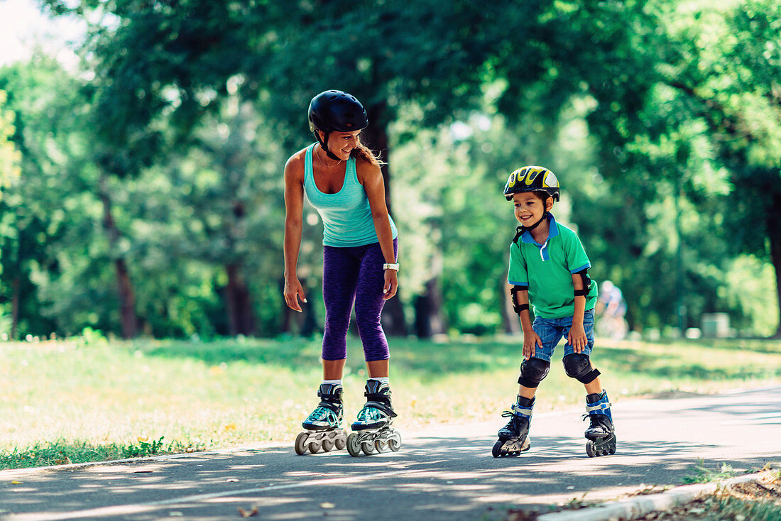 Mother teaching son to roller skate in park