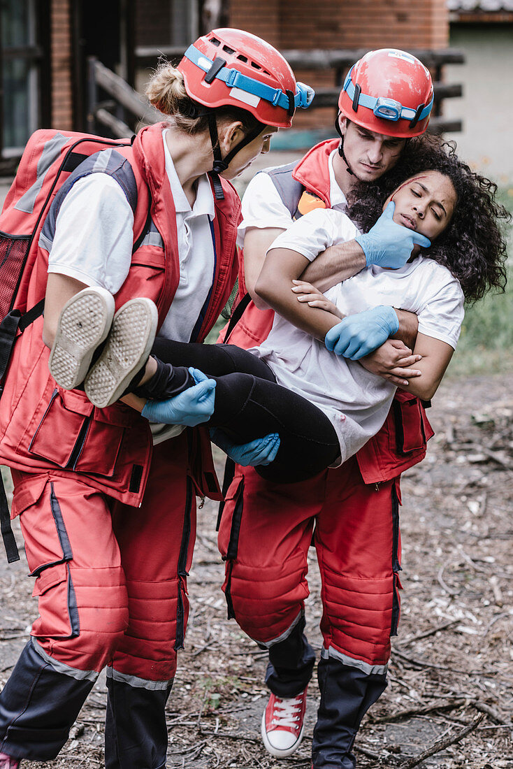 Rescue team evacuating woman from house