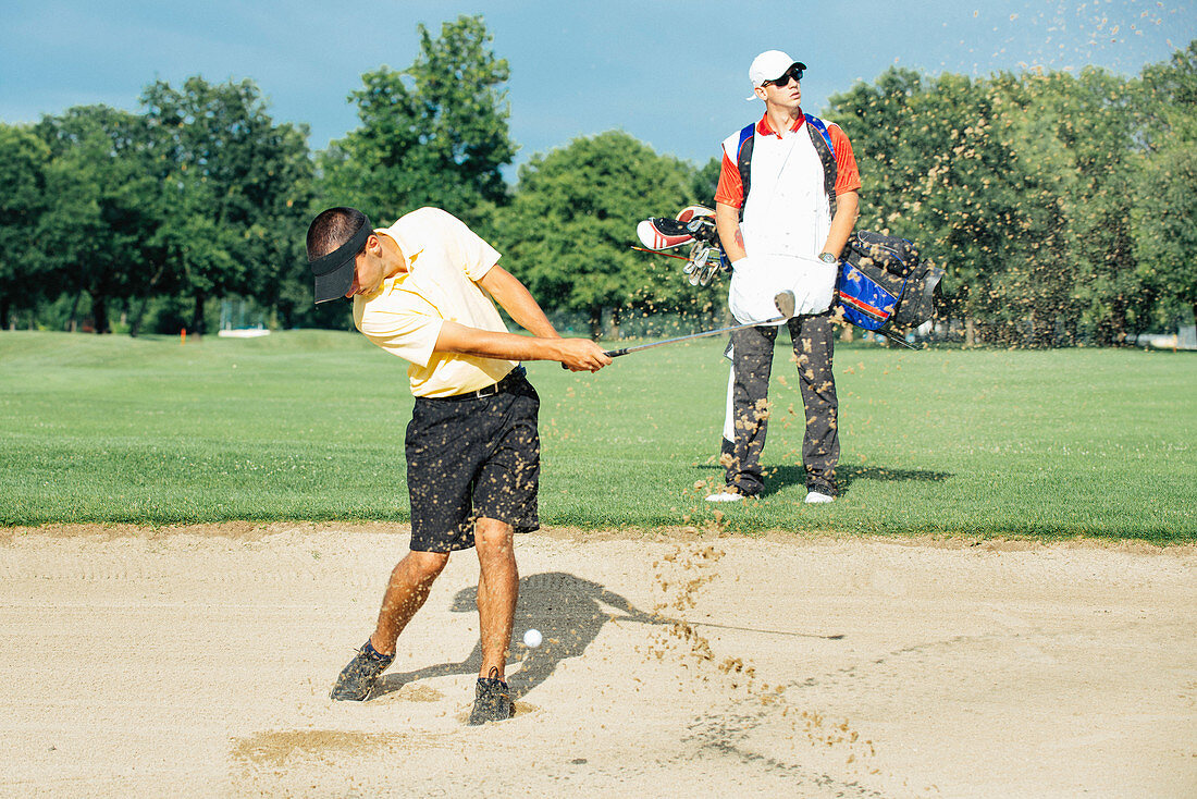 Golfer playing from bunker