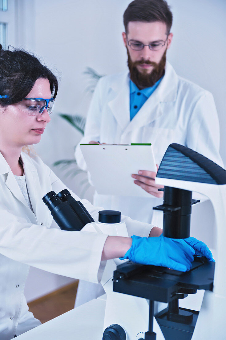 Scientist using microscope