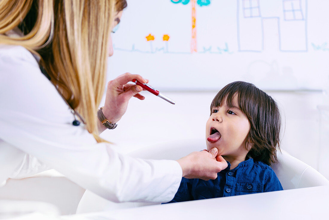 Paediatrician examining boy's throat