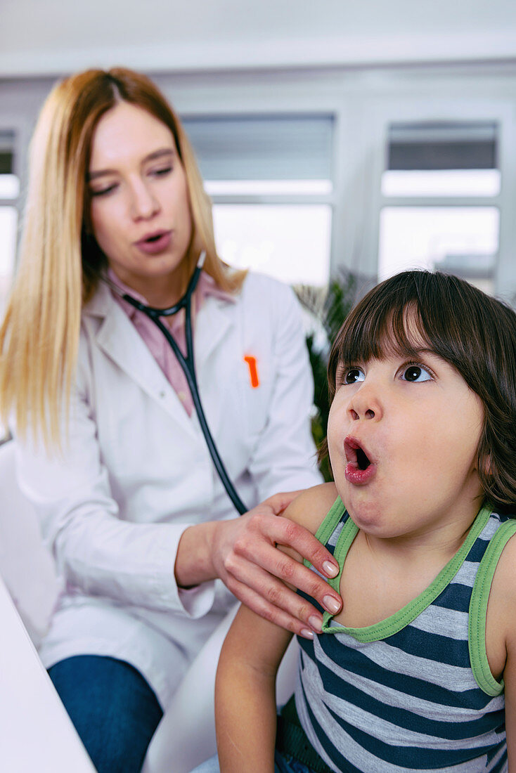 Paediatrician examining boy with stethoscope