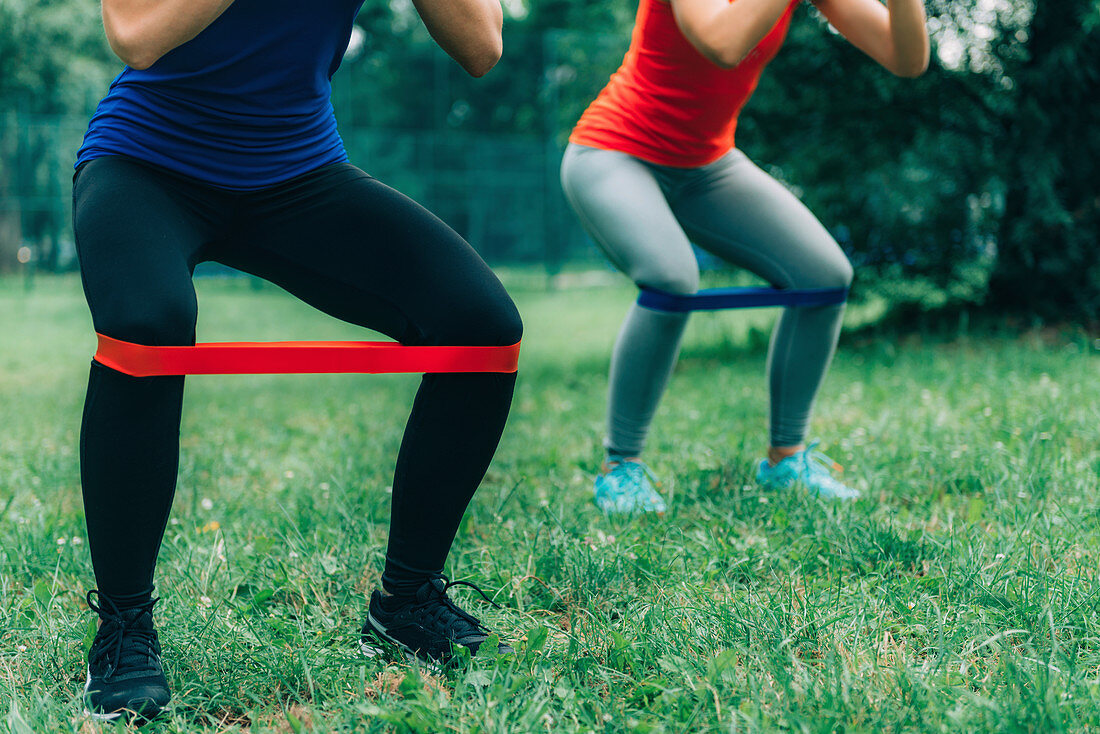 Women exercising with elastic bands in a park