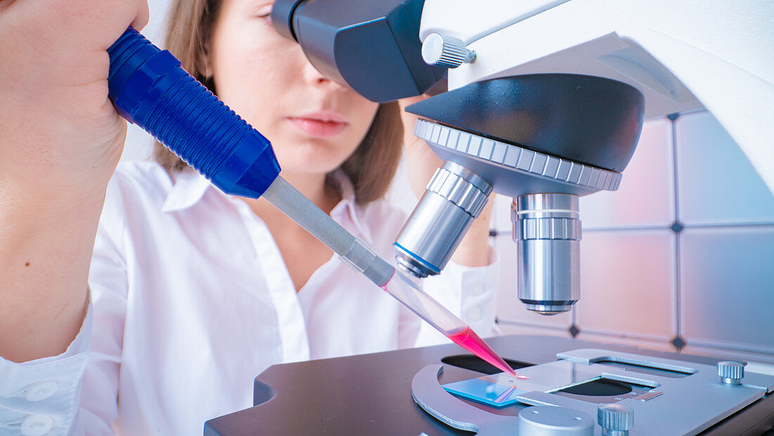 Researcher using microscope