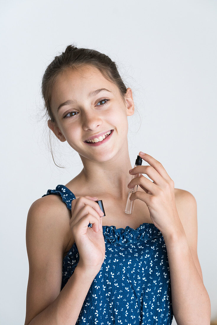 Young girl applying perfume