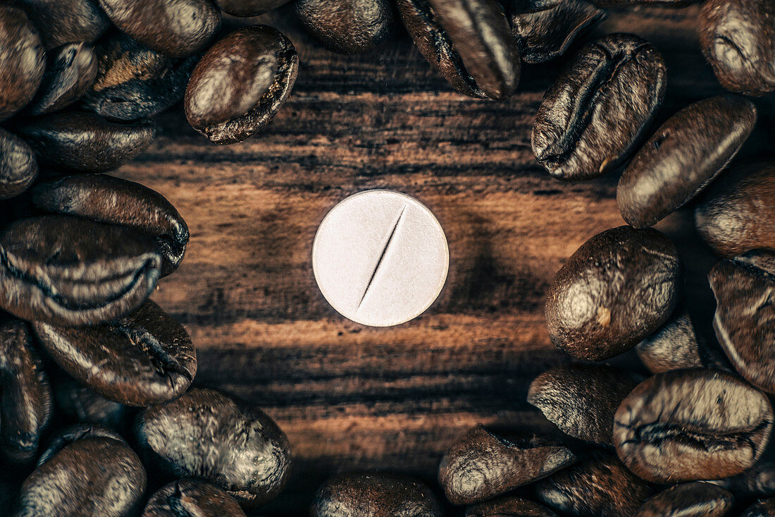 Caffeine supplement pill and coffee beans