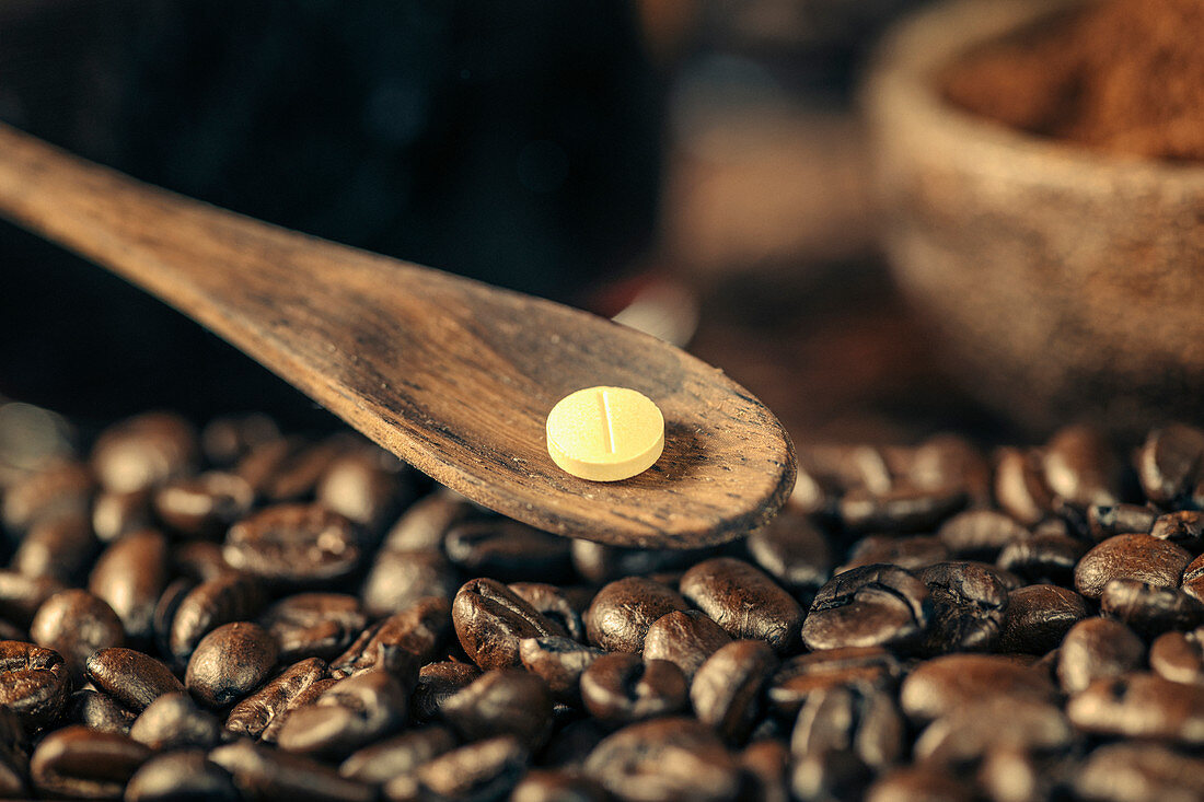 Caffeine supplement pill and coffee beans