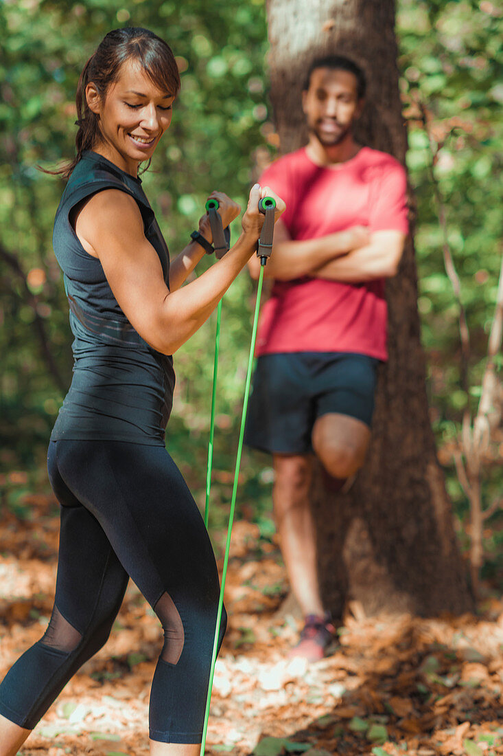 Young couple exercising with elastic resistance band