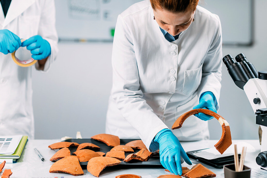 Archaeologists reconstructing broken pottery